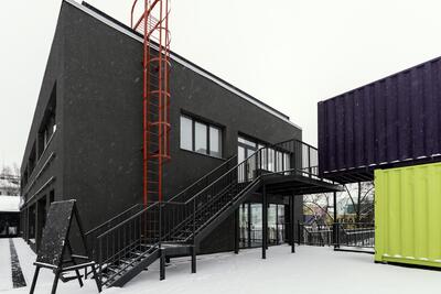 Construção com contêiner container marítimo neve escada prédio preto roxo e amarelo verde zinz reforma