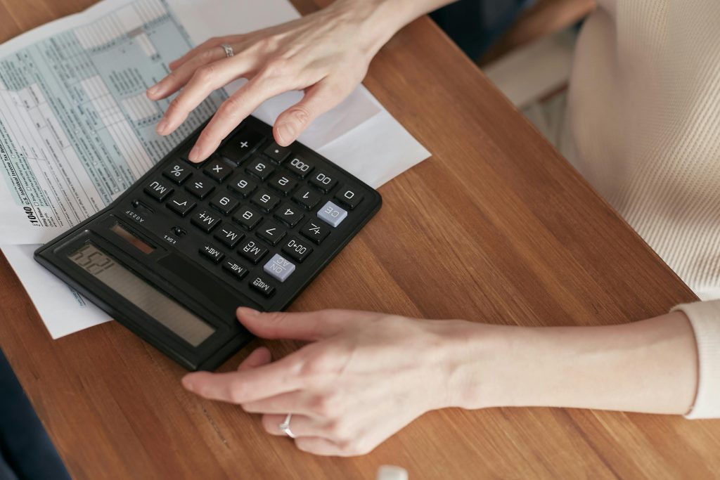 Pessoa calculando quanto custa abrir uma franquia com loja física em planilha de custos