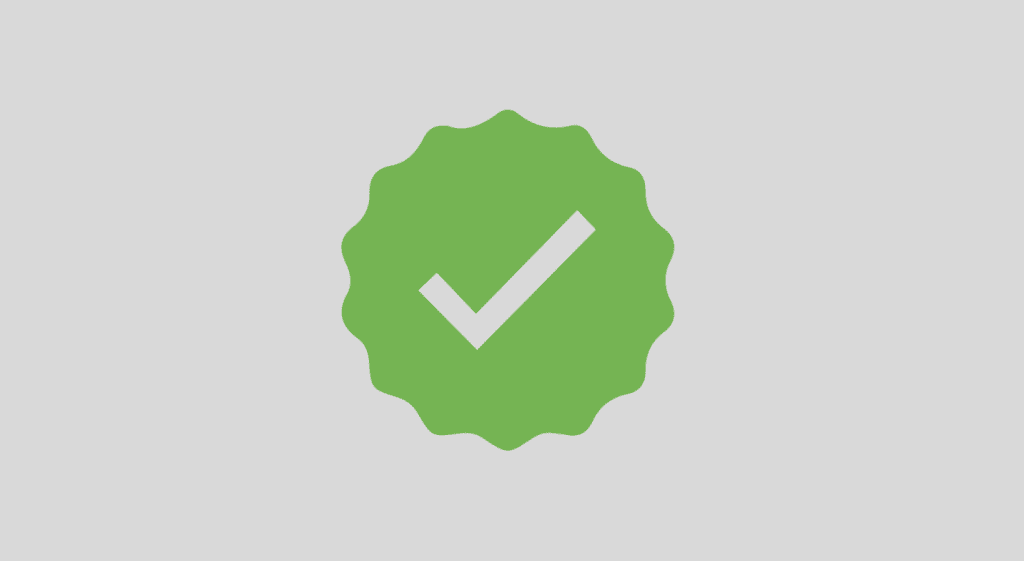 Selo verde com marca de verificação branca no centro, representando aprovação e segurança